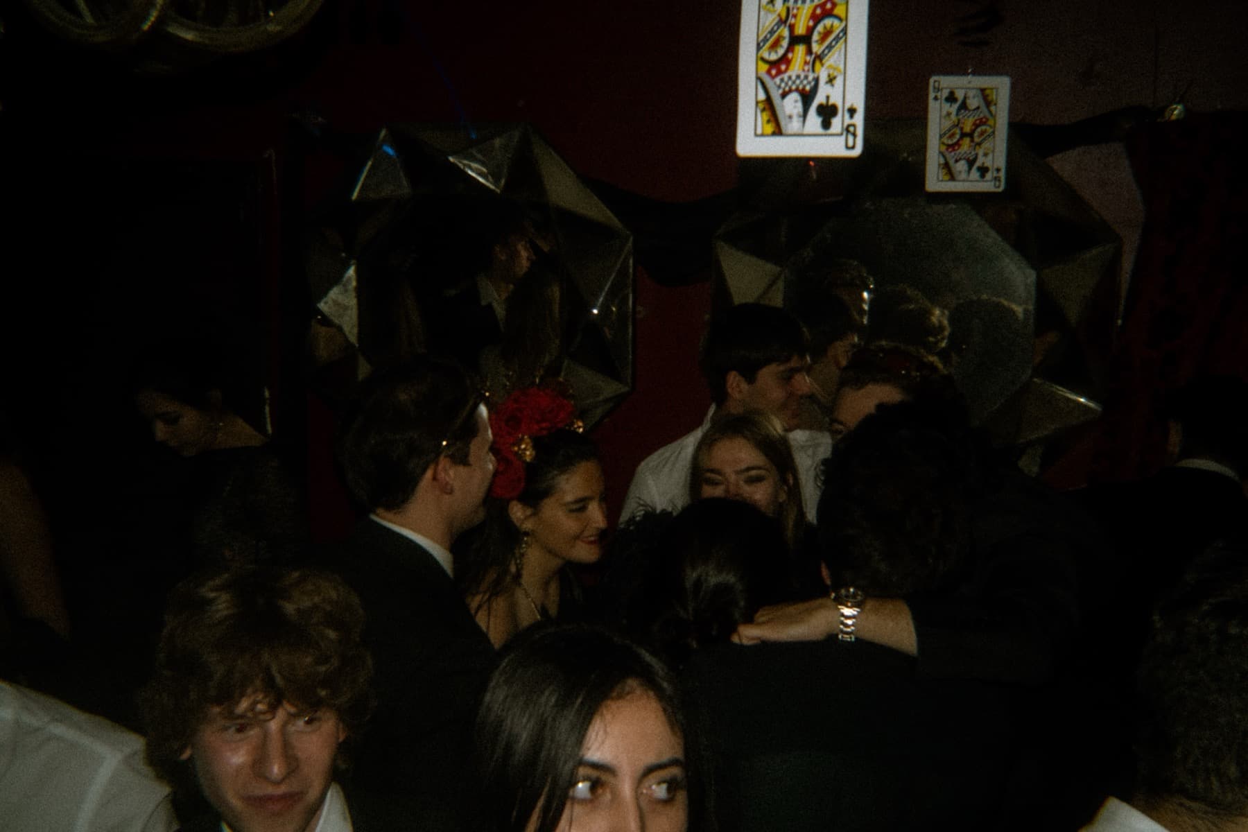 Guests mingling under star-shaped mirror decorations and oversized playing cards on the wall