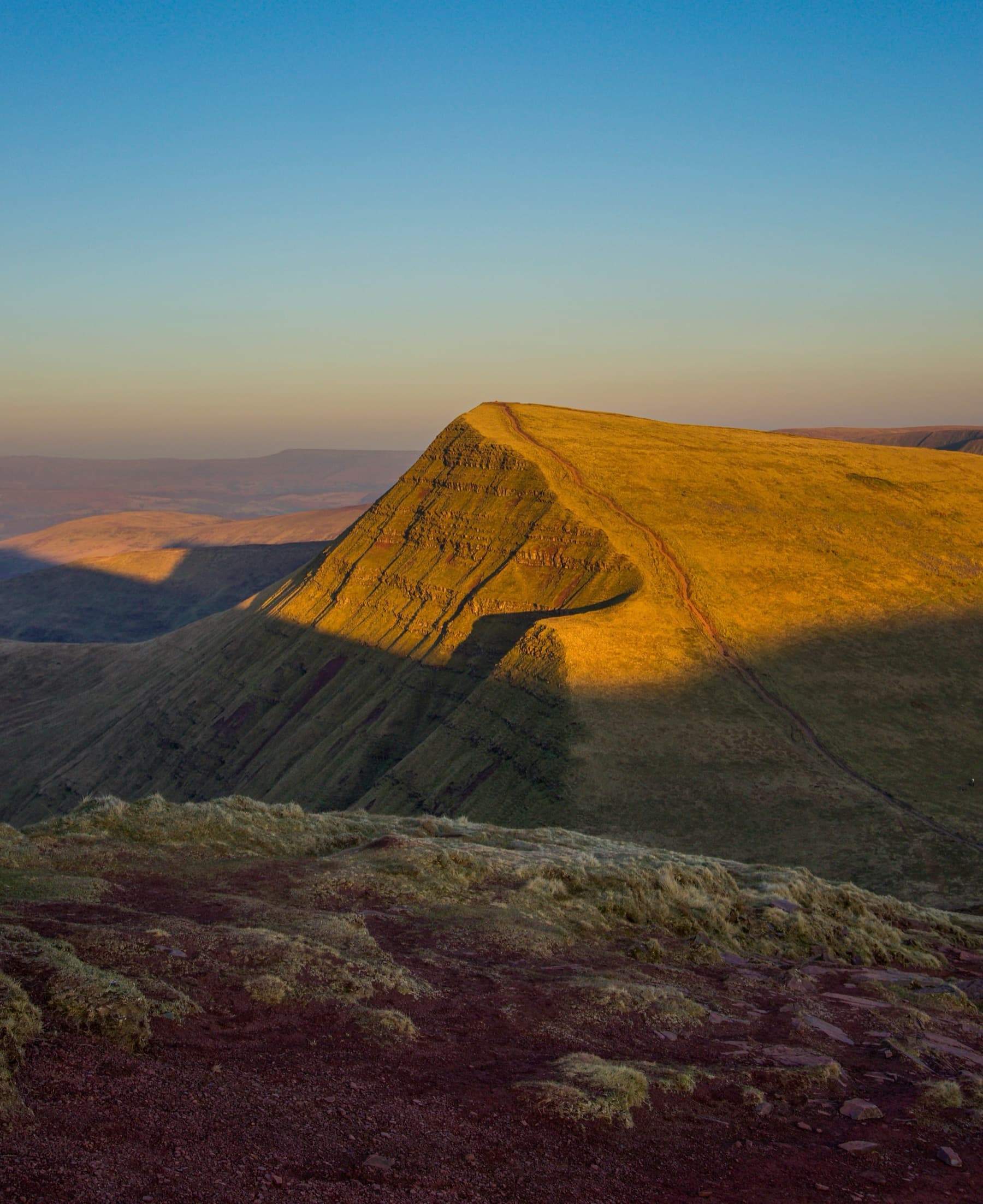 Cribyn summit bathed in golden sunrise light with its distinctive pointed ridge and steep eroded face